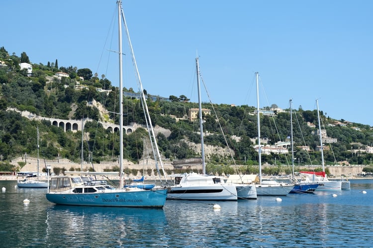 Sailboats anchored in the harbor in Villefranche-sur-Mer, France
